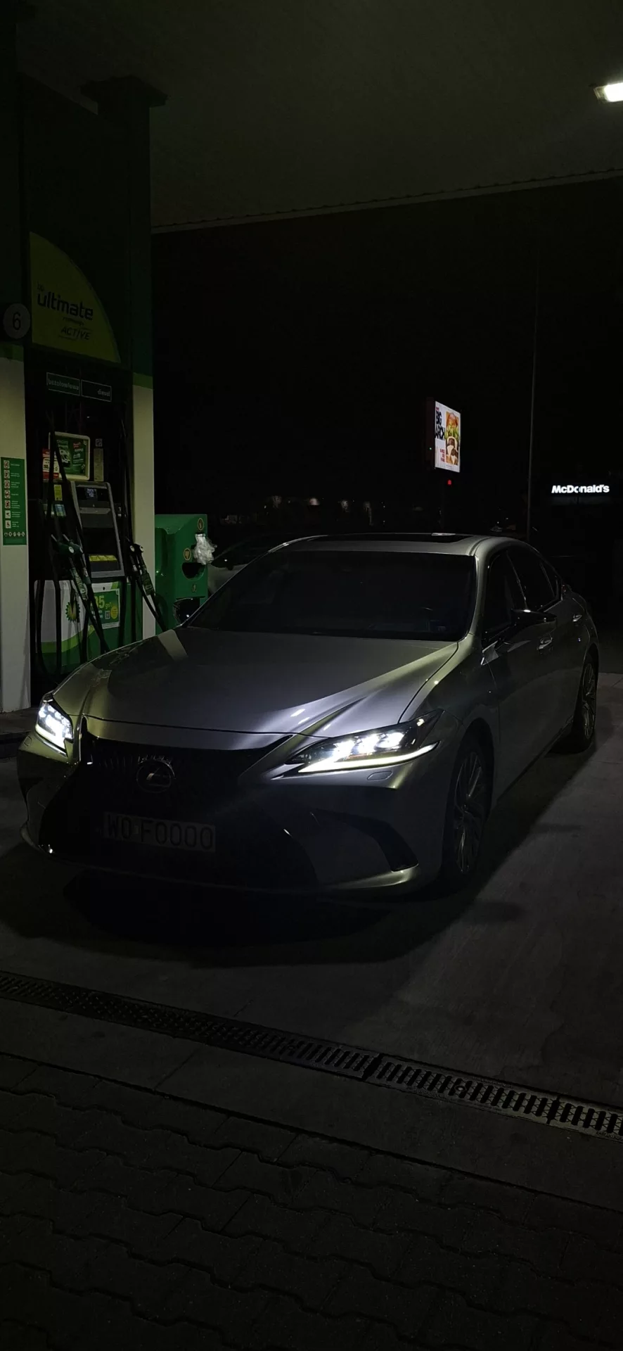 Lexus ES300h nocą na stacji paliw